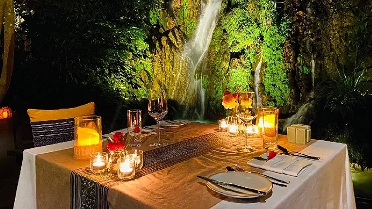 Ăn tối cùng với nến và hoa hồng bên thác nước