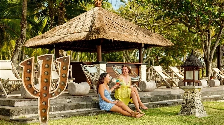 Khu thư giãn ven biển với ghế nằm và mái lá Bali truyền thống